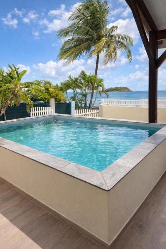 a swimming pool with a view of the ocean at Bibi Beach Sunrise in La Trinité