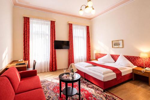 a hotel room with a bed and a red couch at HPA Hotel Andreas in Vienna