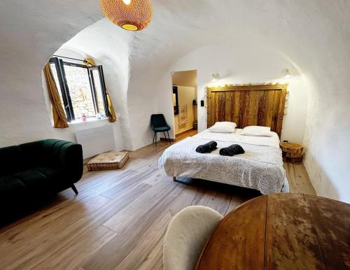 a bedroom with a bed and a table in a room at Le petit refuge in Allos