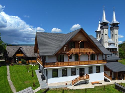 a large house with a castle in the background at Pensiunea Maramu in Breb