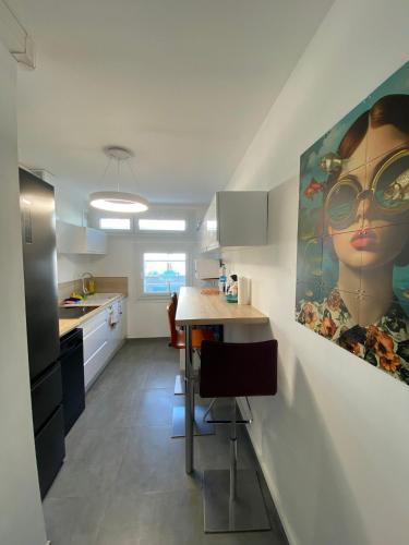 a kitchen with a large painting of a woman on the wall at Le balcon du square in Rennes
