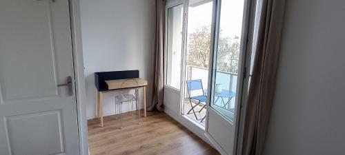 a room with a door to a balcony with a table and chairs at Le balcon du square in Rennes