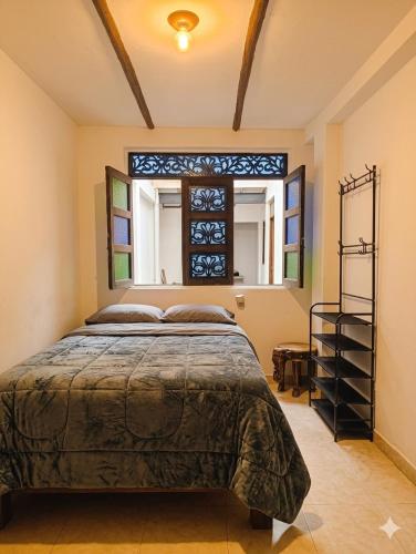 ein Schlafzimmer mit einem Bett und einem Fenster in der Unterkunft Casa Tsao in Bogotá