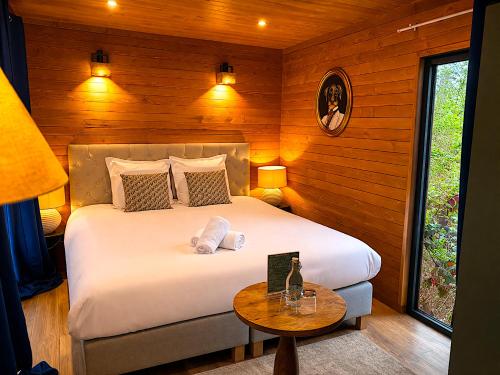 a bedroom with a large bed and a table at Hotel Les Lodges de Vaugrigneuse in Vaugrigneuse