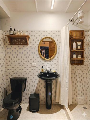 ein Badezimmer mit Waschbecken, Toilette und Spiegel in der Unterkunft Casa Tsao in Bogotá