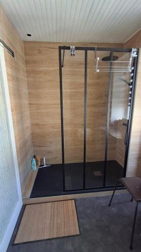 a shower in a room with a wooden wall at Chez Laurence in Locronan