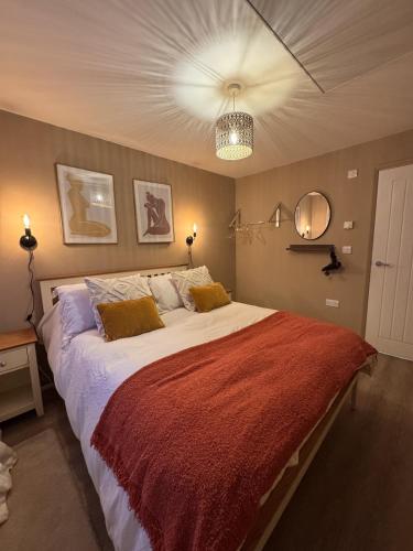 a bedroom with a large bed with a red blanket at The Lazy Fox, Shrewsbury in Shrewsbury