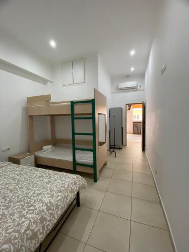 a bedroom with a bed and a room with a hallway at Corinth Beach Apartment and Hostel in Korinthos
