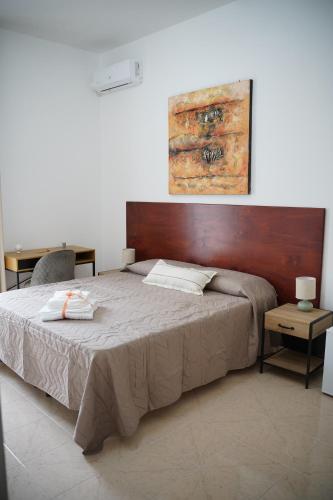 a bedroom with a large bed with a wooden headboard at Giocca Rooms in Palagiano