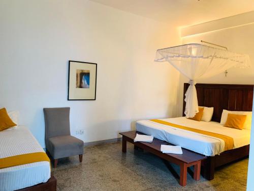 a bedroom with a bed and a desk and a chair at Airport Heritege in Negombo