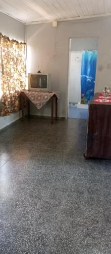 a room with a table and a tv in it at tómate un descanso in Salto