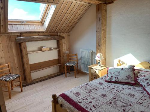 a bedroom with a bed in a room with a window at L'écho des Artois in Uzelle