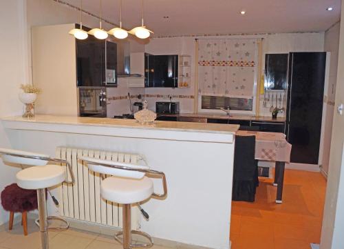 a kitchen with a counter and a bar with stools at Duplex T3 résidence Djnen el Bey in Annaba