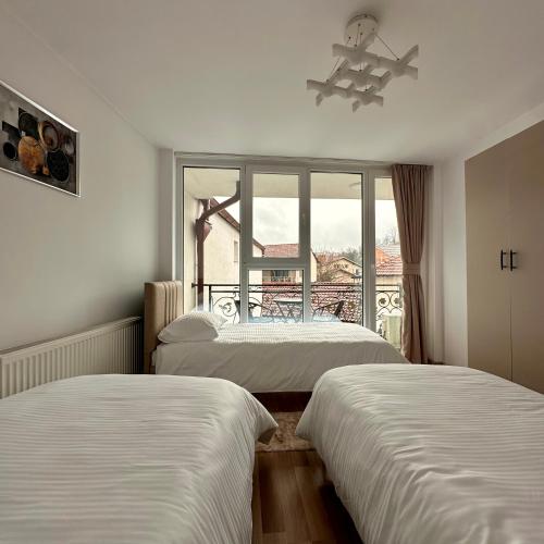 two beds in a room with a window at In The House Hostel in Prishtinë