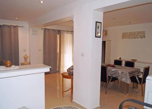 a living room with a table and a dining room at Duplex T3 résidence Djnen el Bey in Annaba