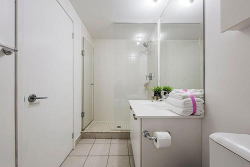 a white bathroom with a sink and a shower at Adelaide Stays and Suites - Walk to Subway - Easy Access Downtown Toronto in Vaughan