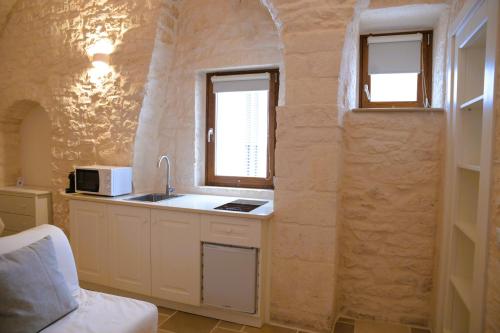a kitchen with a sink and two windows at Campanile Inn in Locorotondo