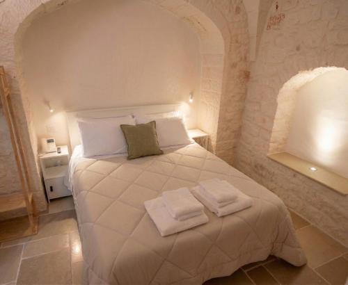 a bedroom with a bed with two towels on it at Campanile Inn in Locorotondo