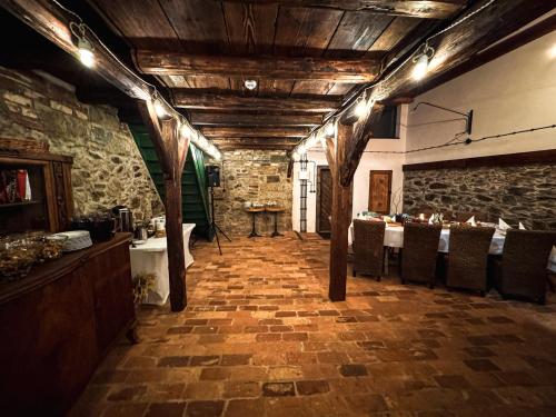 ein Esszimmer mit einem Tisch und einer Steinwand in der Unterkunft Dobre Historie duży dom na wyłączność sauna, balia, blisko Zamku Czocha in Leśna