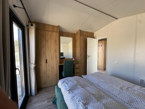 a bedroom with a bed and a desk and a window at EkoOazy nad Jeziorem in Firlej