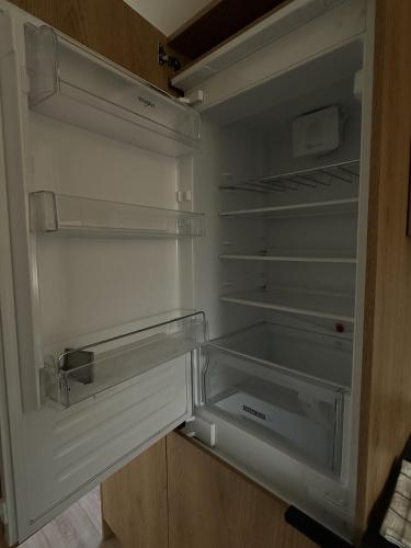an empty refrigerator with its door open in a kitchen at EkoOazy nad Jeziorem in Firlej