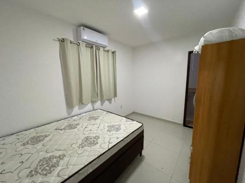a small bedroom with a bed and a window at Cantinho Jauá 3 in Camaçari