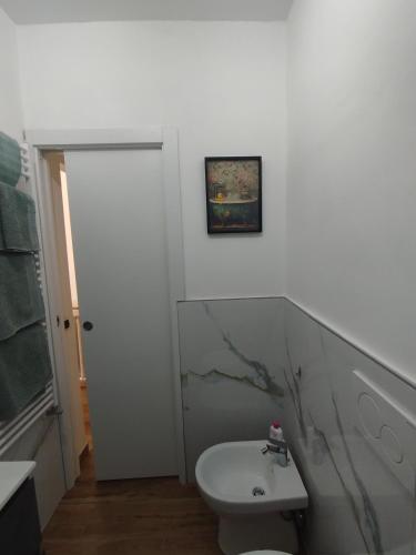 a bathroom with a white toilet and a sink at Bilocale Home Project 2 in Novara