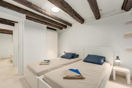 two beds in a room with white walls and blue pillows at Villa Amanda by CVR in Roústika