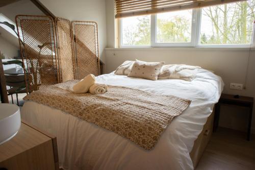 a bedroom with a large bed with a window at Polderloft 27 in Hengstdijk