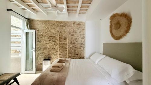 a bedroom with a large bed and a stone wall at TarifaMiCasa Amor de Dios in Tarifa