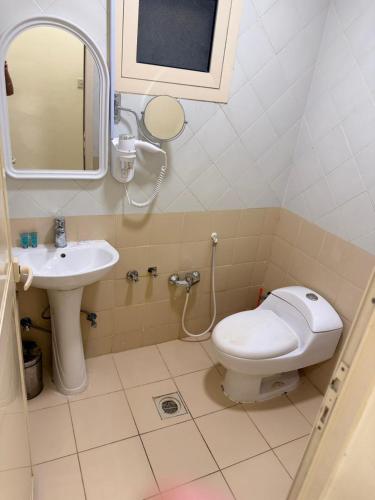 a bathroom with a toilet and a sink at واحة الاحساء للشقق المخدومة in Al Hofuf