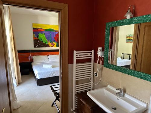 a bathroom with a sink and a mirror and a bedroom at Casaliva Relais in Bardolino