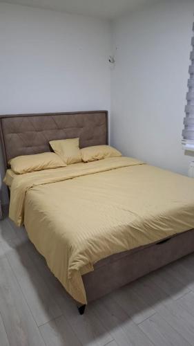 a large bed in a bedroom with a bed frame at Quiet apartment in Hadžići