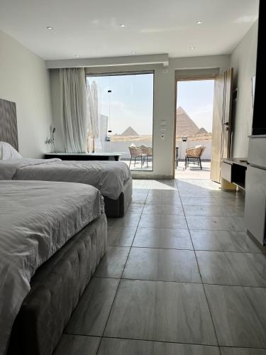 a bedroom with two beds and a view of the desert at pyramids shadow inn hotel in Cairo