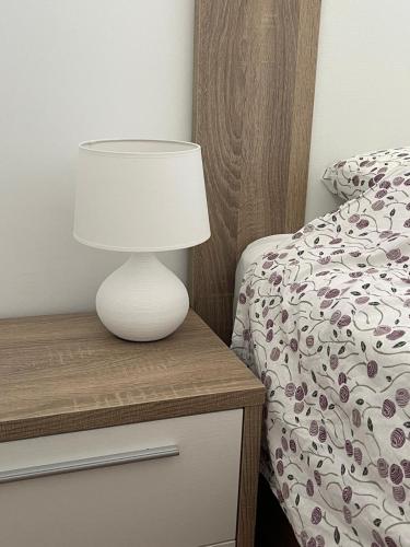 a white lamp on a nightstand next to a bed at Penismar Azul in Peniscola