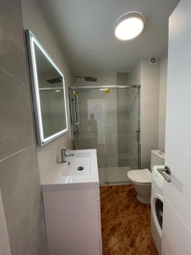 a white bathroom with a sink and a toilet at Penismar Azul in Peniscola