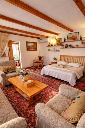 a bedroom with a bed and a couch and a table at Caravanà Resort in Yeghegnadzor