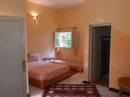 a bedroom with two beds and a window at Chez Moulay Ismail in Agdz