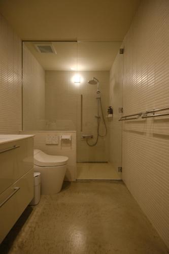 a bathroom with a shower and a toilet and a sink at ERUMAYA Resort in Motobu