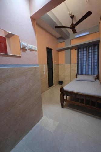 a bedroom with a bed and a ceiling fan at FlexTays Transit - Station Side Stays in Trivandrum