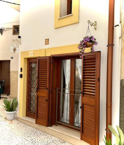 a house entrance with wooden doors and flowers at Borgo Antico in Grottaglie