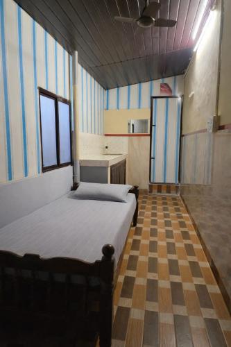 a bedroom with a bed and a checkered floor at FlexTays Transit - Station Side Stays in Trivandrum