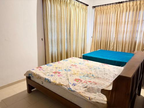 a bedroom with a bed and a window with curtains at Arora Villa in Digana