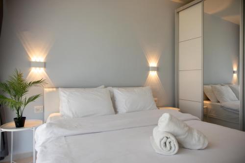 a bedroom with a white bed with a towel on it at Liz suite in Caesarea