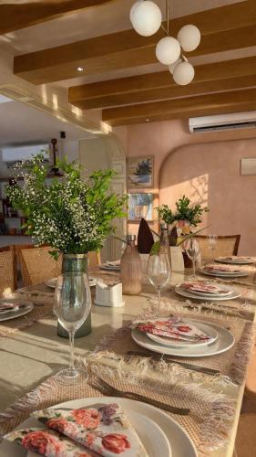 a table with plates and wine glasses on it at The Elysian Morjim 150 Meters to Morjim Beach in Morjim
