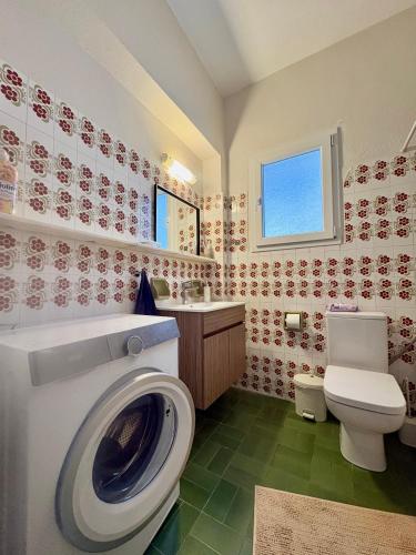 a bathroom with a toilet and a washing machine at Radio House in Myrina
