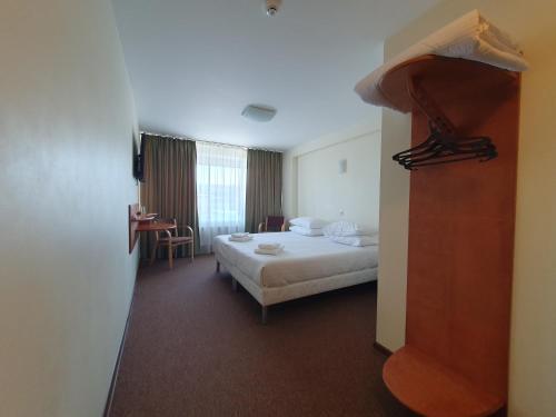 a hotel room with a bed and a table at Hotel Madona in Madona