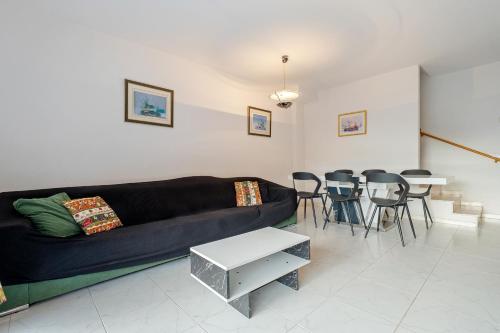 a living room with a couch and tables and chairs at Hauzify I Casa Arboç in Platja d'Aro