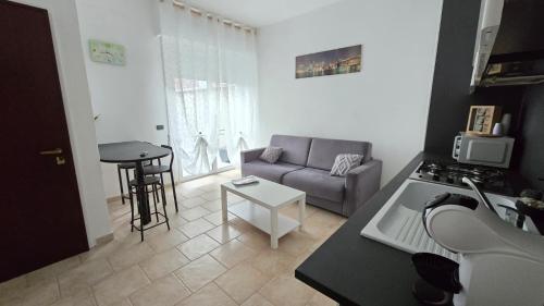 a kitchen and living room with a couch and a table at Faraboni Apartments in Novara