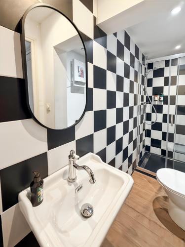 a bathroom with a sink and a mirror at Rockefeller - Le petit Loft New-Yorkais 5 Min de la plage in Dunkerque